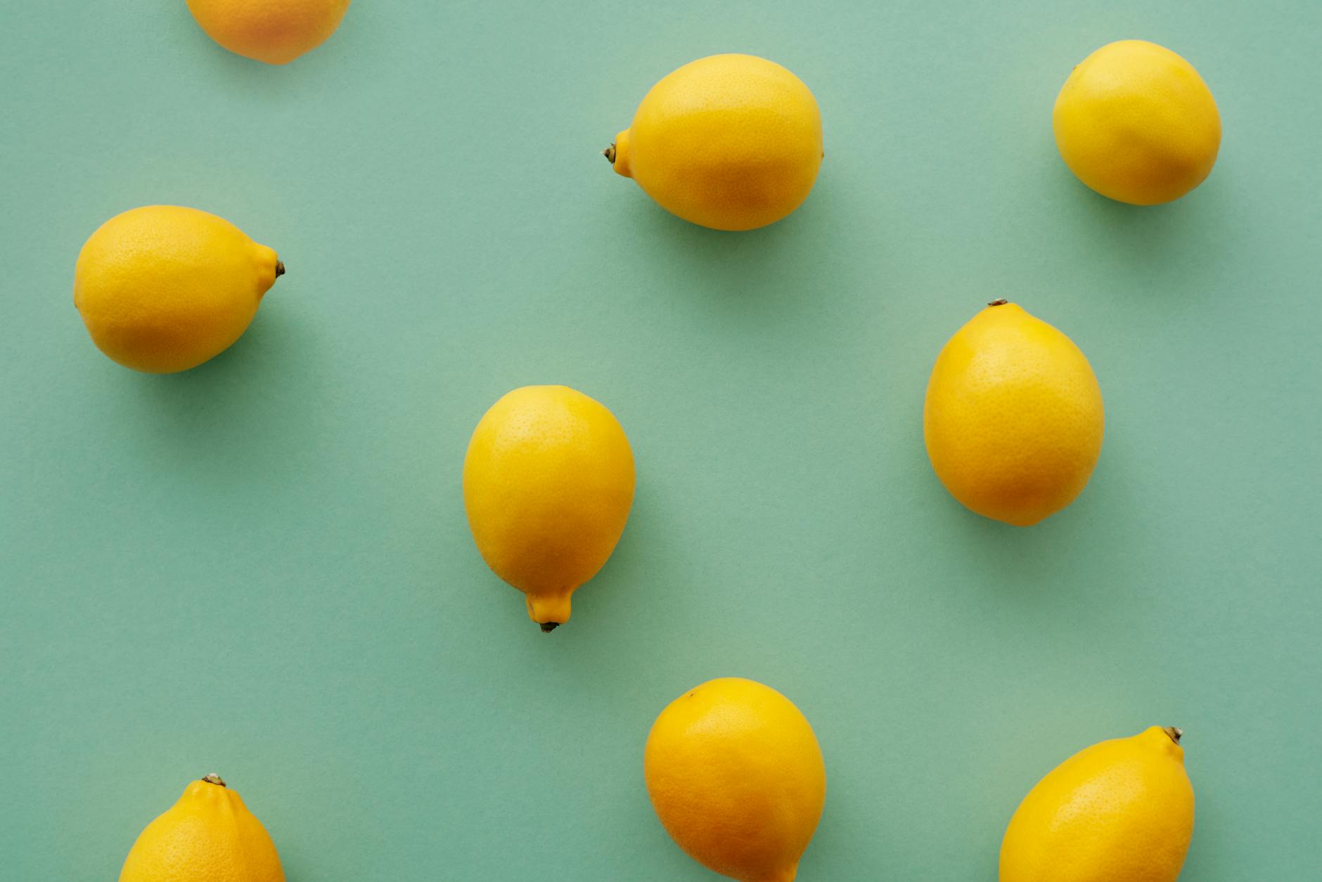 Bright yellow lemons arranged on a pastel background, representing the lemon clitoral vibrator