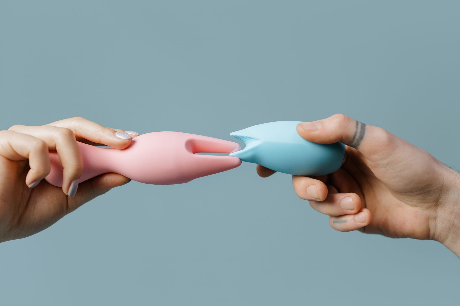 Hand holding a fresh lemon on soft pink background, representing natural pleasure restoration